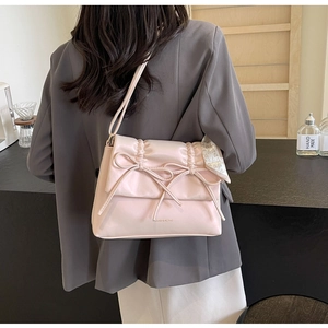 Détail du sac à bandoulière rose clair avec plis fins, nœuds et foulard en soie décoratif