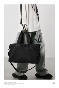 Détails du grand sac de voyage noir avec poignées renforcées et bandoulière amovible