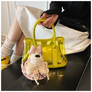 Détail du sac seau transparent jaune avec pochette en cuir et breloque chien peluche