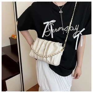 Detail of off-white ruched cloud bag with large pearl strap and gold metal chain