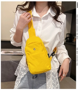 Close-up of bright yellow nylon crossbody bag featuring metal zipper and adjustable strap