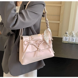 Détail du sac bandoulière rose style ballet avec nœuds et foulard à cœurs