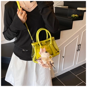 Détail du sac seau transparent en PVC vert fluo avec charm chiot en peluche et pochette interne