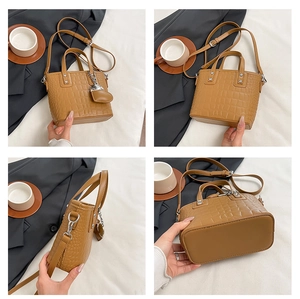 Detail shots of a brown crocodile pattern mini tote bag with silver hardware and a heart charm