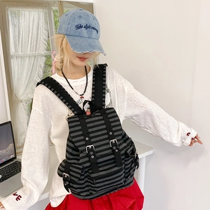 Detail showing retro striped backpack with flap buckle closure and drawstring design