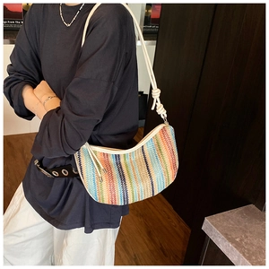 Detail of multi-colored woven straw crossbody bag with rope knot shoulder strap