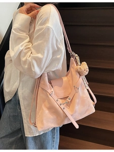 Pink nylon flap shoulder bag with cute bear charm for daily casual wear on model
