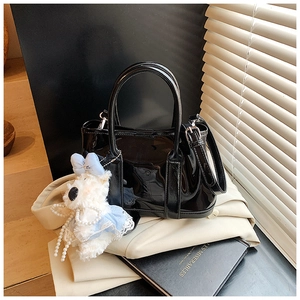 Sac seau noir brillant avec deux poignées et un charmant petit chien en peluche blanc