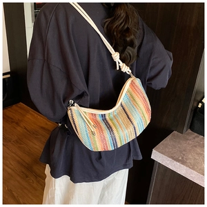 Rainbow striped woven hobo bag with white leather strap shown on shoulder for casual look