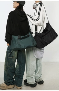 Sacs de voyage spacieux en nylon noir et vert foncé portés par des modèles avec sangle