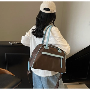 Detailed side view of high-capacity brown nylon travel bag with light blue leather trim