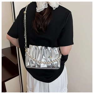 Detailed view of pleated silver shoulder bag with faux pearl chain and metallic finish