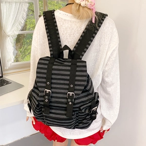 Detail of retro striped canvas backpack with adjustable straps and side pockets on a model