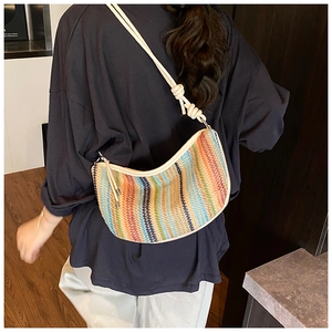 Detail of colorful rainbow woven bag with stylish knotted shoulder strap on a model