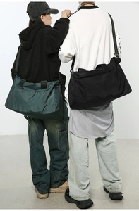 Vue arrière de grands sacs de voyage verts et noirs avec bandoulières réglables en nylon