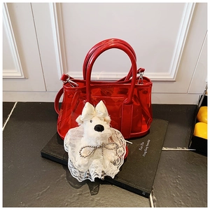 Détail du sac seau rouge translucide avec un joli accessoire de charme chiot en peluche