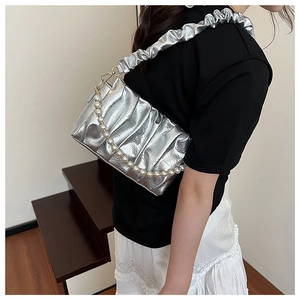 Detail of silver ruched shoulder bag with pearl chain strap and metallic finish