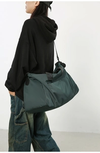 Sac de voyage vert foncé pour femme montrant la grande capacité en porté épaule