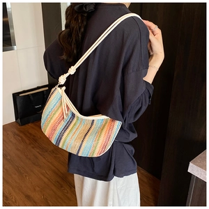 Detail of colorful woven hobo bag with vibrant stripes and casual rope shoulder strap
