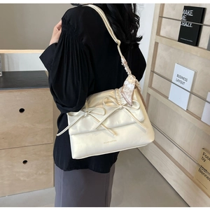 Détail du sac crème à nœuds avec foulard à motifs cœurs et double nœud décoratif