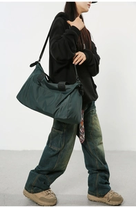 Sac de voyage en nylon vert foncé avec bandoulière montré dans un cliché professionnel