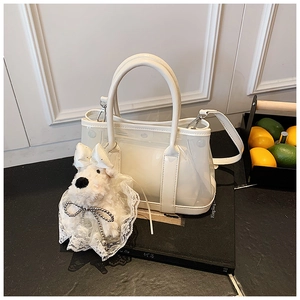 Détail du sac seau blanc semi-transparent avec breloque chien en peluche et pochette