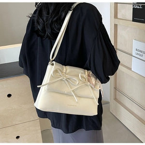 Vue détaillée du sac crème avec des nœuds élégants et un foulard en soie imprimé