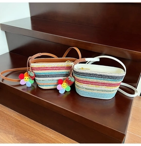 Détails des sacs seaux en paille colorée avec bandoulières en cuir et charmes fleuris