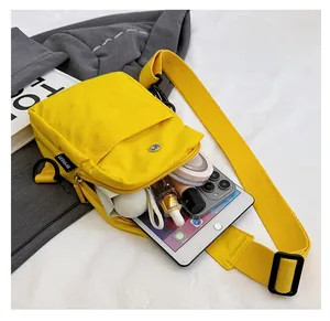 Detail showing high-capacity interior of yellow nylon crossbody bag with essentials