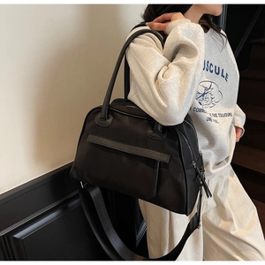 Dettaglio borsa da viaggio in nylon nero con tracolla larga in tessuto rimovibile e comoda