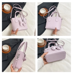 Detailed views of light purple crocodile embossed bucket bag with crossbody strap