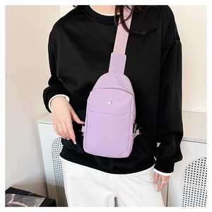 Close-up of light purple nylon chest bag with woven strap worn by a model