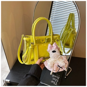 Détail du sac seau jaune transparent avec bordure en similicuir et breloque chiot