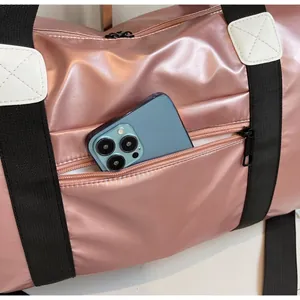 Detalle del bolso de viaje rosa con bolsillo lateral de cremallera para un smartphone