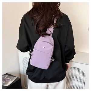 Close-up of purple nylon chest bag with adjustable strap and multiple zip pockets