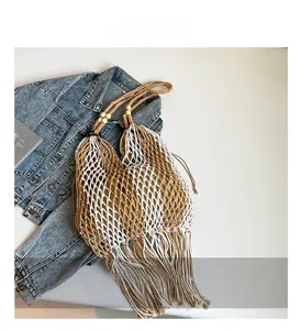 Detail of woven beach tote showing hollow mesh texture and stylish tassel fringes