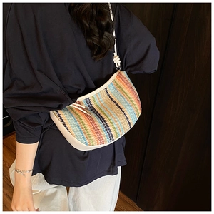 Detail of colorful woven shoulder bag with white leather strap and knot on a model