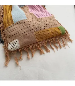 Close-up of handmade knit tote bag featuring colorful patchwork and long tassels decoration