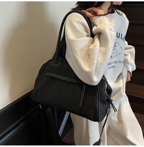 Vista laterale di una borsa da viaggio nera con finiture in pelle e zip metalliche