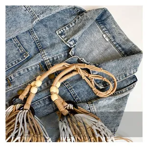 Detail of woven tote bag strap with wooden beads and textured rope on denim