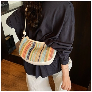 Detail of colorful striped woven shoulder bag with bohemian texture and knot strap