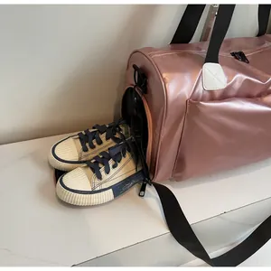 Detalle de bolsa de viaje rosa metalizada con compartimento lateral para calzado