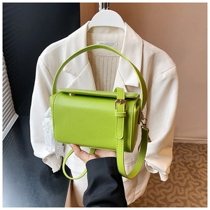Close-up of apple green lychee texture handbag with adjustable strap and lace decor