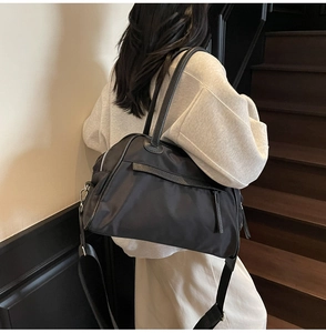 Dettaglio della grande borsa da viaggio nera con tessuto resistente e tracolla rimovibile