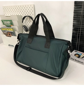 Détail du sac de voyage vert foncé imperméable avec bandoulière et poche avant