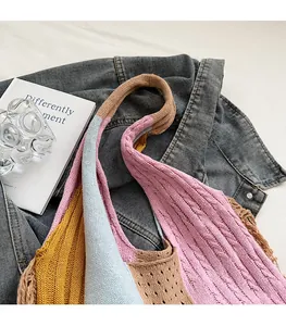 Detail of multi-color knit tote bag with wide soft shoulder strap and hollow textures