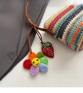 Détail du sac seau tissé coloré avec breloque tournesol et pendentif fraise en gros plan