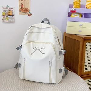 Vue détaillée du sac à dos en toile blanche avec broderie nœud gris et sangles à boucle