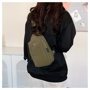Detail of olive green nylon crossbody bag showing the adjustable strap on a female model