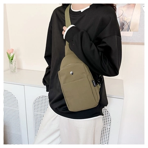 Detail of olive green canvas chest bag showing durable fabric and zipper compartment